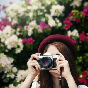 Woman with camera and flowers